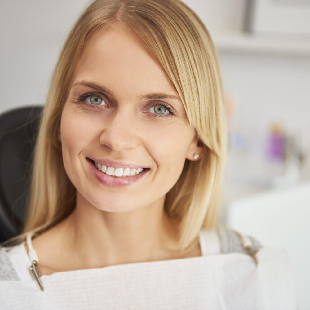 Portrait of pleased and smiling woman in dentist's clinic